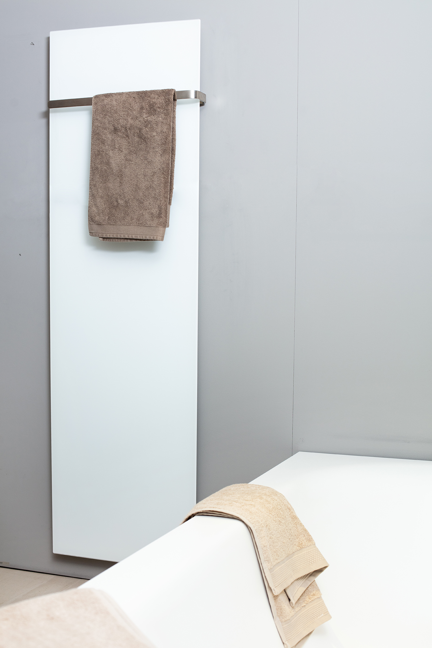 ELEMENTO vertical in Weiss matt mit braunem Handtuch neben der Badewanne